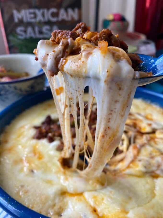 big spoonful of queso and stretched cheese close up