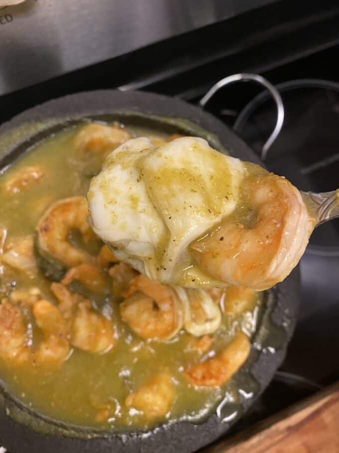 melted cheese with shrimp on spoon close up