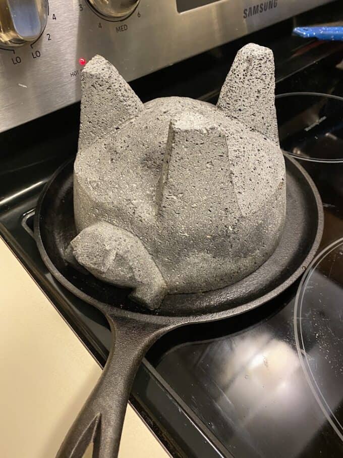 heating molcajete on cast iron griddle, stove top