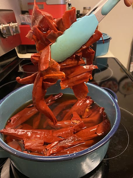 softened red chiles going into the blender jar