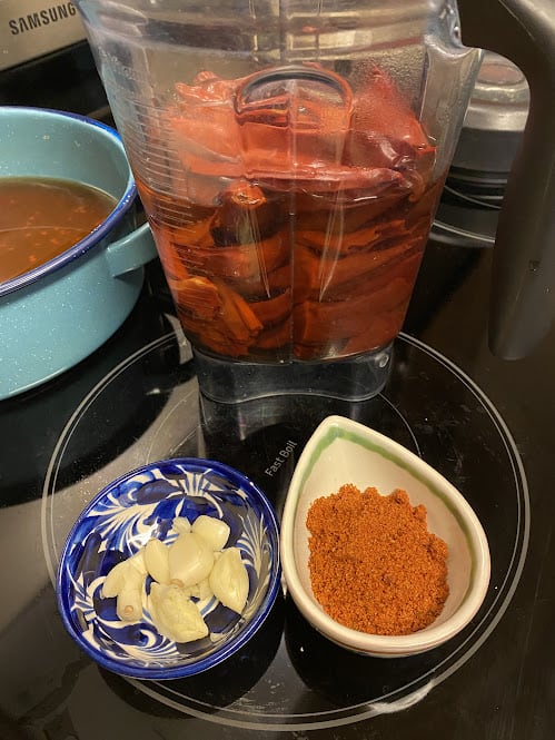 Fresh cloves of garlic in small bowl, tomato bouillon powder in separate bowl