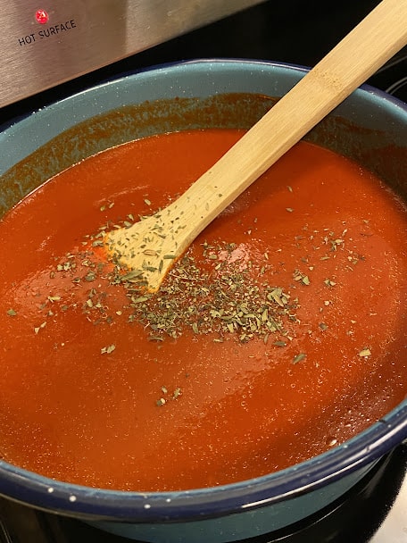 crushed Mexican oregano added to enchilada sauce