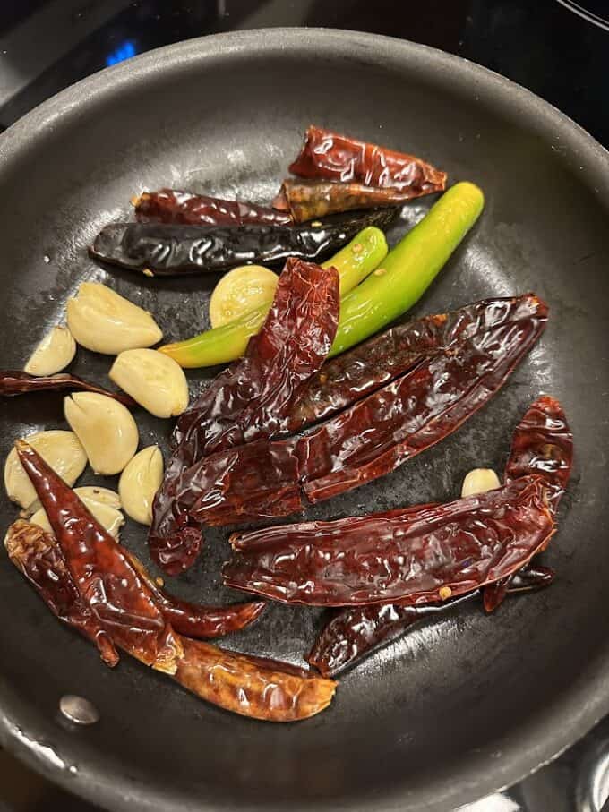 lightly frying red chile sauce ingredients in the skillet