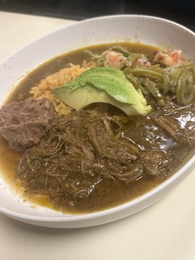 shredded beef plated with rice, beans, avocado