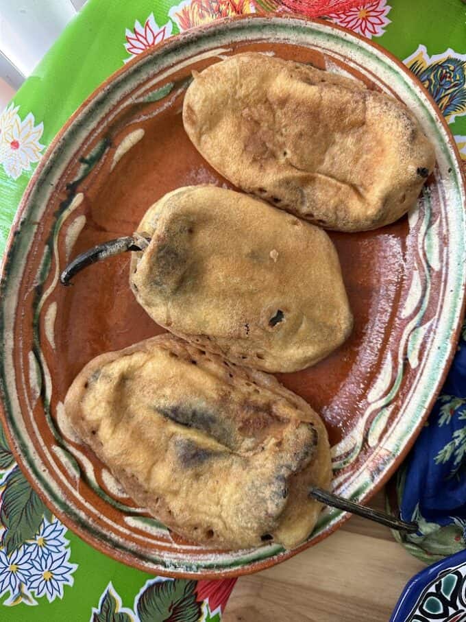 battered and fried rellenos on serviing platter