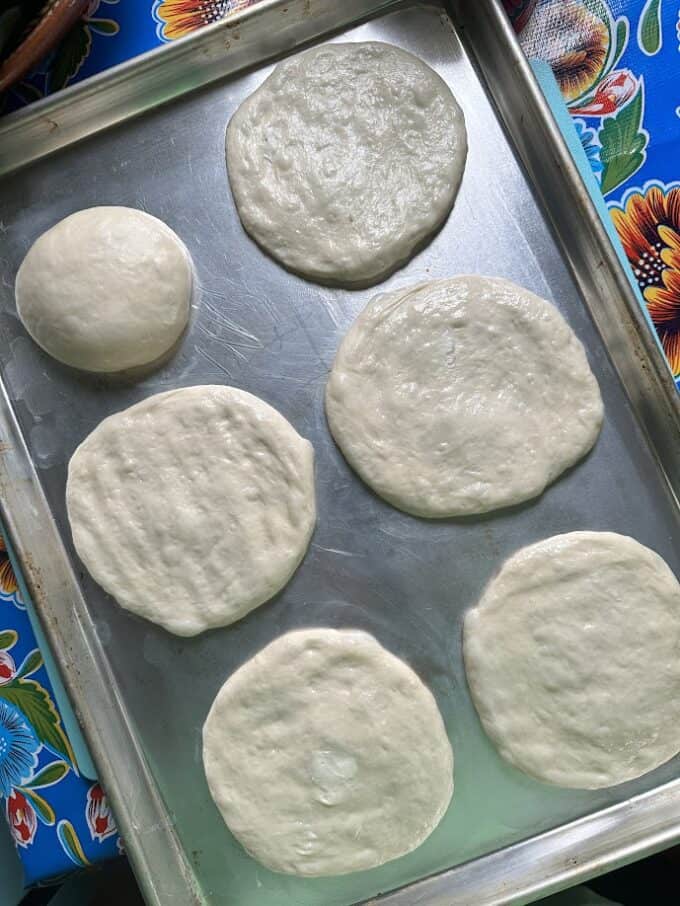 flattening dough on baking sheet