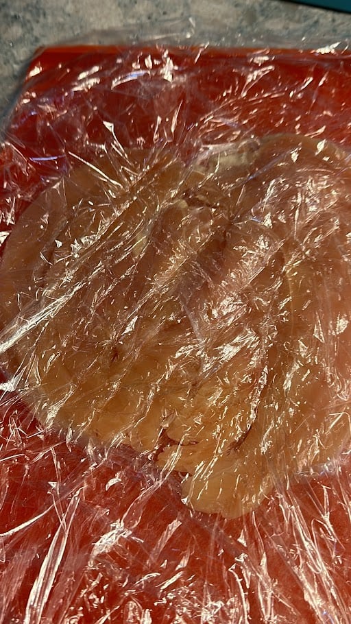 pounded chicken breast in between plastic