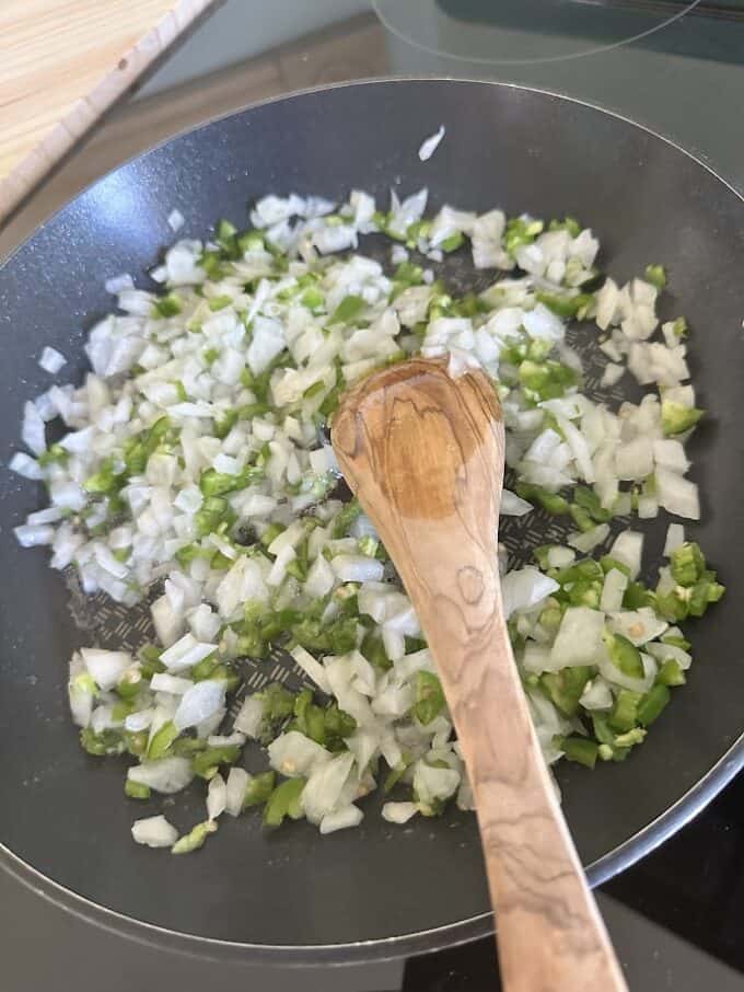 onions and serrano pepper in skillet