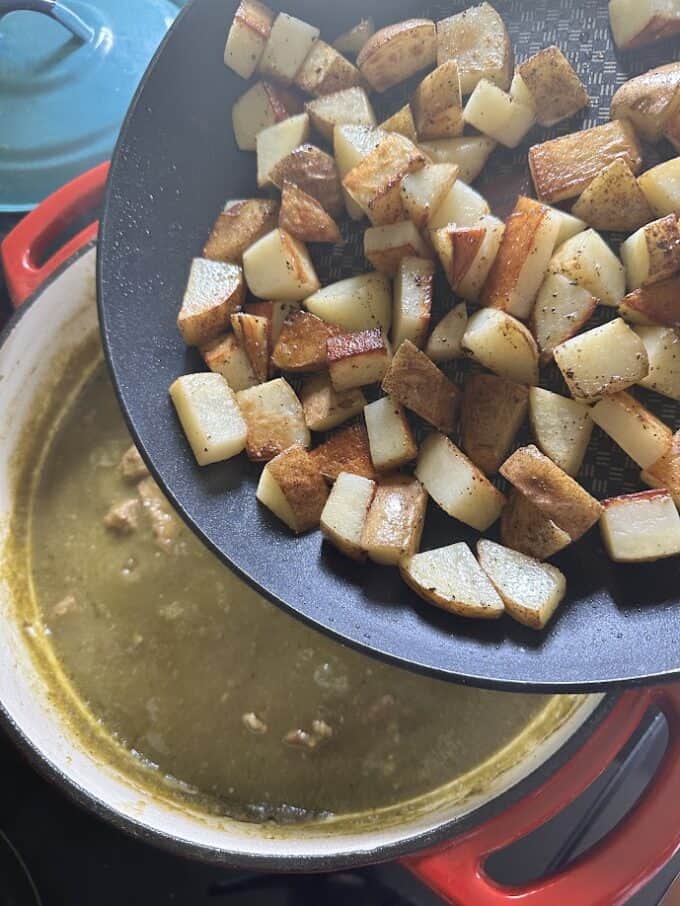 adding fried potatoes to chile verde