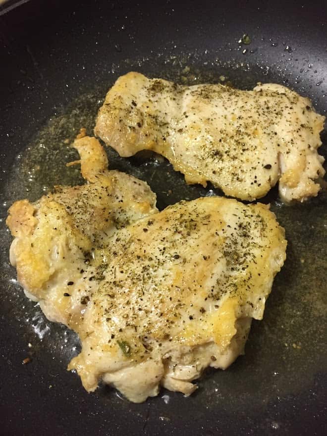 seasoned chicken browning in pan