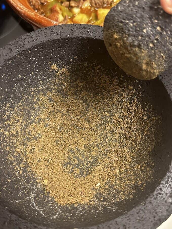 ground cumin seeds and oregano in the molcajete