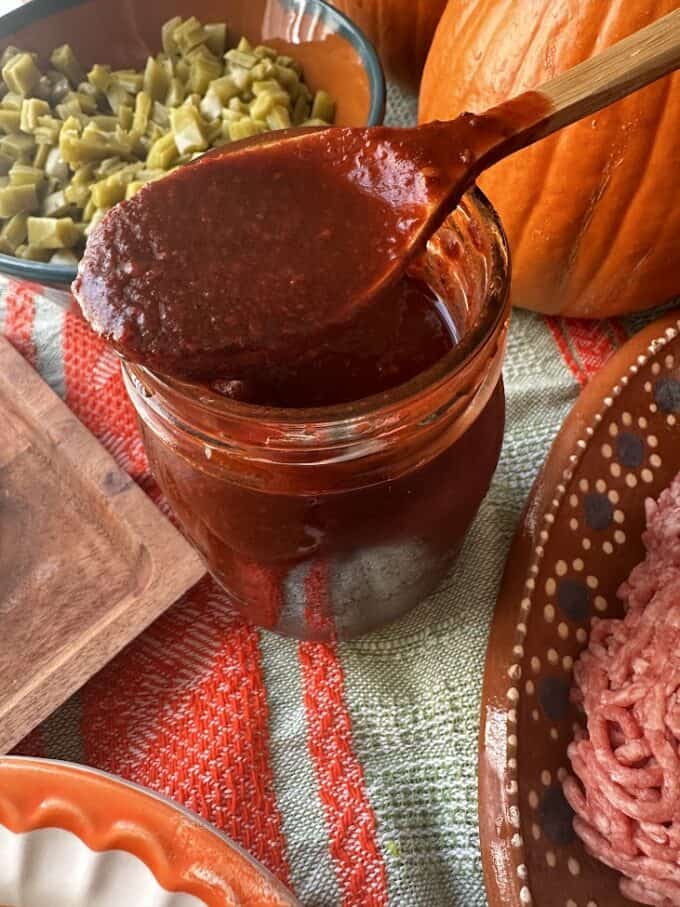 chile ancho sauce in a jar with a spoonful