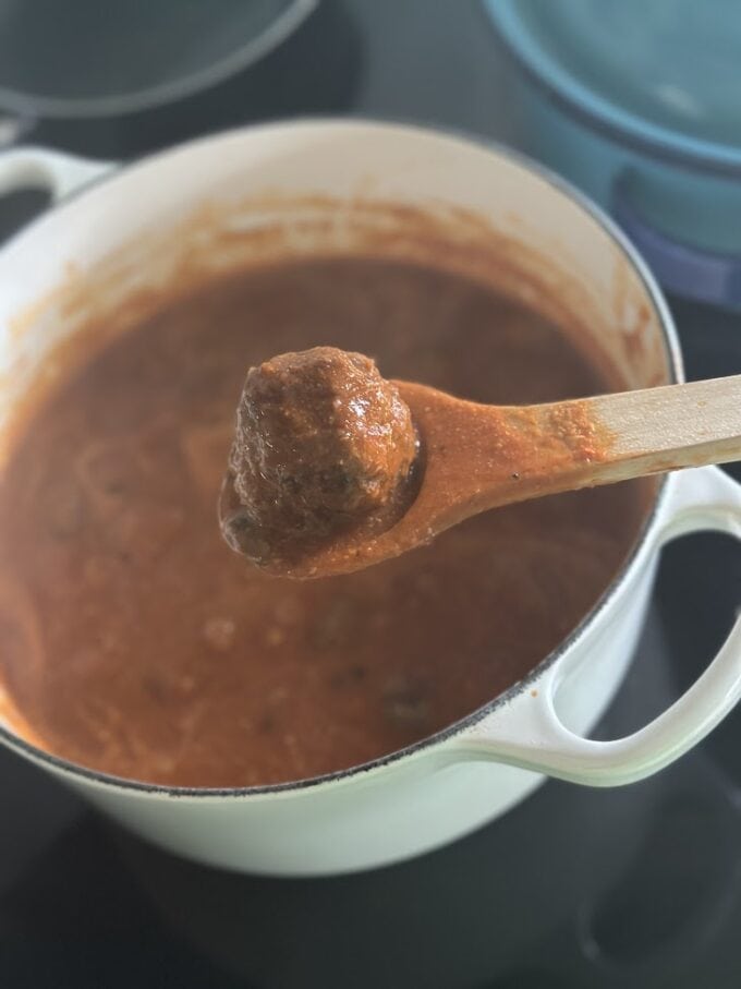 meatballs in sauce on wooden spoon
