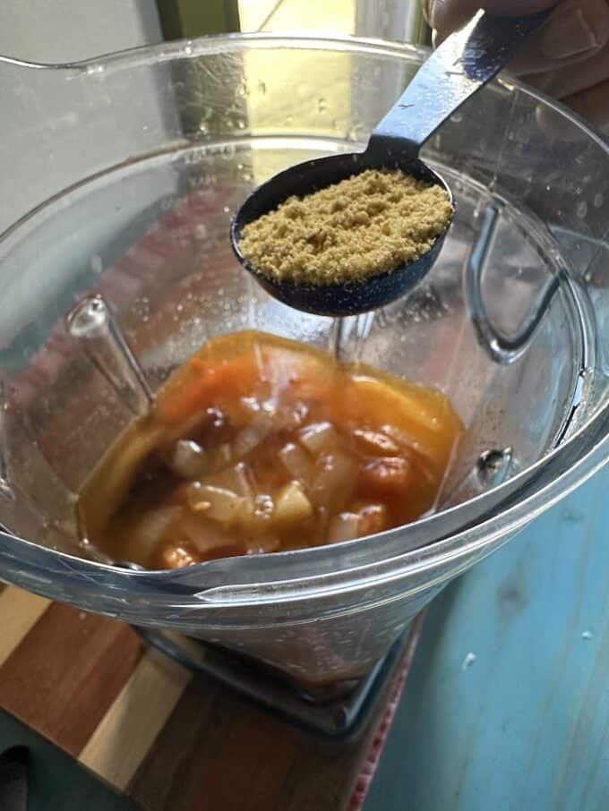 adding bouillon to tomato salsa in blender jar
