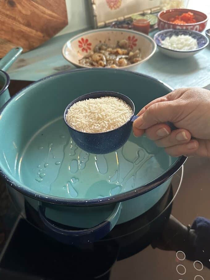 adding the rice to the pot with oil