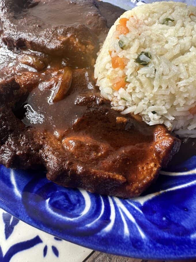 close up of pork chops in salsa negra with rice